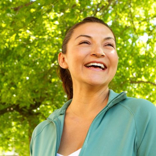 Portrait of a happy Hispanic woman smiling outside.